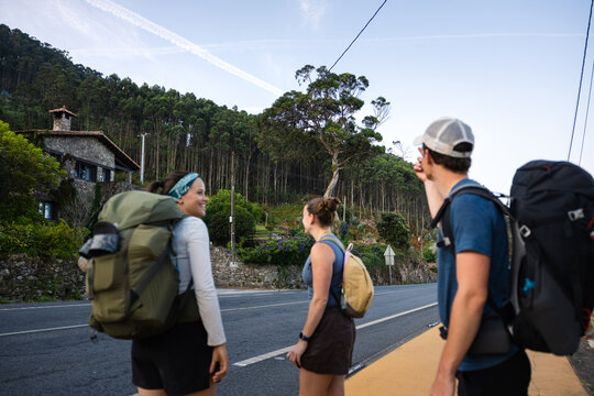 Pilgrims pausing by a stone house on the Camino