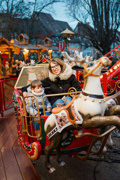 A woman and her son have fun on the carousel in the Amusement park