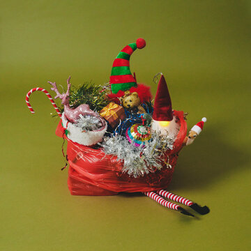 a red plastic bag overflows with colorful Christmas decorations