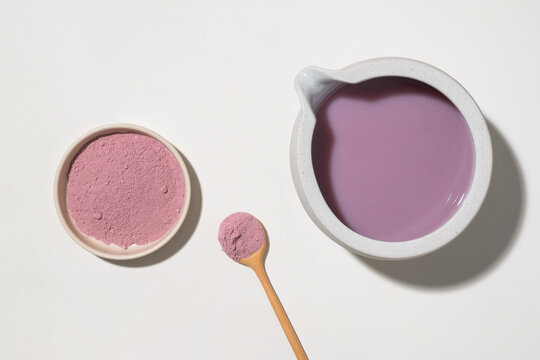Purple superfood powder and liquid in minimalist ceramic dishes