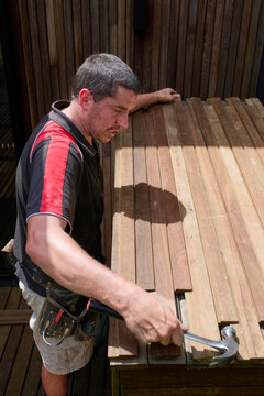 Carpenter Builds Wooden Table in Outdoor Setting