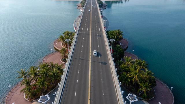 Aerial view of tropical cross‑sea road bridge with moving cars