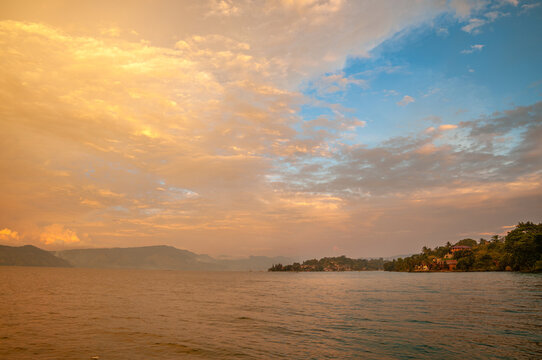 Scenic golden hour sunset over Lake Toba and Samosir Island in Sumatra