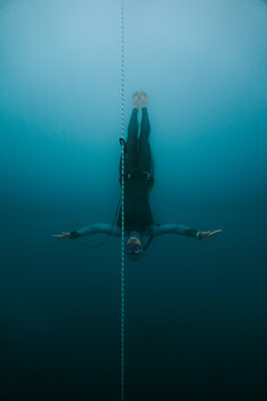 freediver floating freely beside a depth line