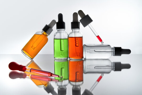 Orange, Green, Red Serum Dropper Bottles With Laboratory Glassware