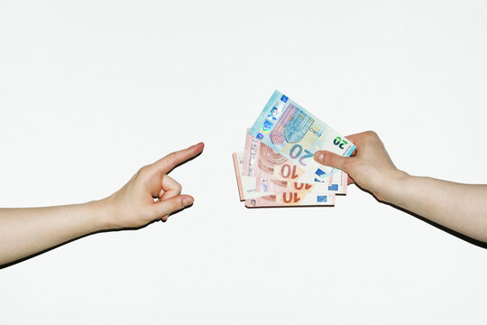 Person pointing money cash payment that other person offers