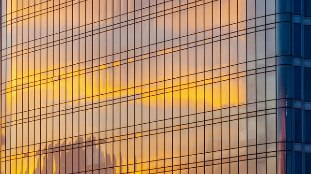 Glass facade reflecting sunset glow, horizontal