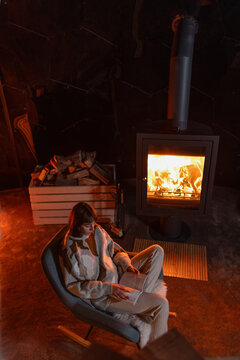 Cozy Woman Reading by a Wood-Burning Stove