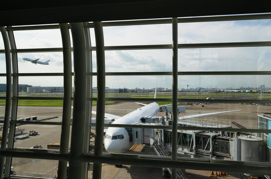 Passenger Aircraft at Airport Gate Viewed Through Terminal