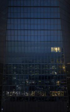 Office building at night with single illuminated window