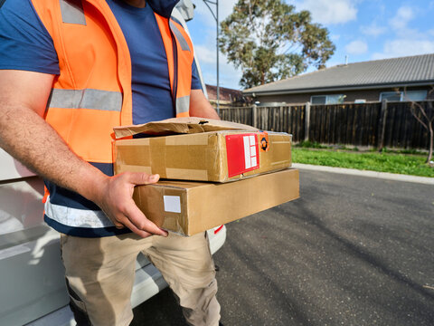 Delivery Person Carries Packages on a Sunny Day