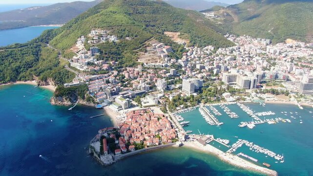 Aerial drone view of Budva Old Town Stari Grad and the adjacent luxury yacht marina along the scenic Adriatic coast of Montenegro