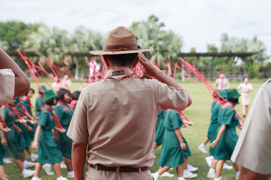 Rear View of Scoutmaster Saluting During Student Scout Parade Review on School Field