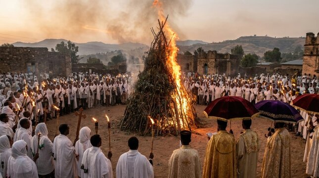 Meskel religious festival showing orthodox christian priest, demere bonfire ceremony, celebration with torch, traditional ethiopian robe, umbrella, flame ritual outdoor.