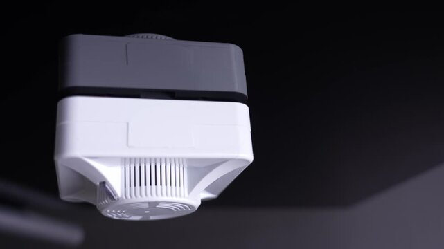 Smoke detector on black ceiling, white BUM makes fire detector go off. Fire alarm