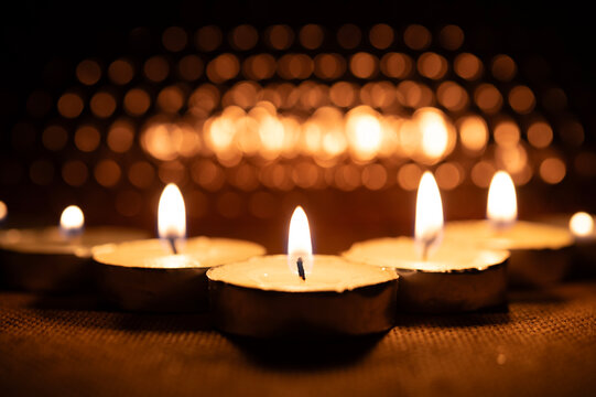 Glowing Candle Flame in Warm Bokeh for All Saints Day Memorial