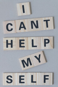 "i cant help myself" sign composed of wood tiles with black sans serif font on cardboard