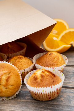 Sweet pastry. Citrus muffins. Home kitchen recipe preparation. Golden treats baked in paper liners served with craft package free space.