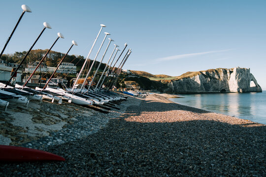Row of sailing boats parked on the pebble beach at Etretat during a sunny day in Normandy France