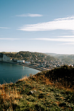 Scenic view of Etretat town nestled along the white chalk cliffs and coastline in France at daytime