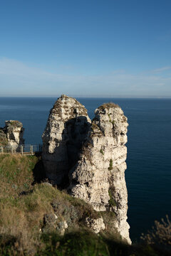 White chalk cliffs rising above the blue English Channel in Etretat during a sunny afternoon time