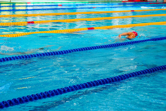 Swimmers training or competing in a bright blue pool.