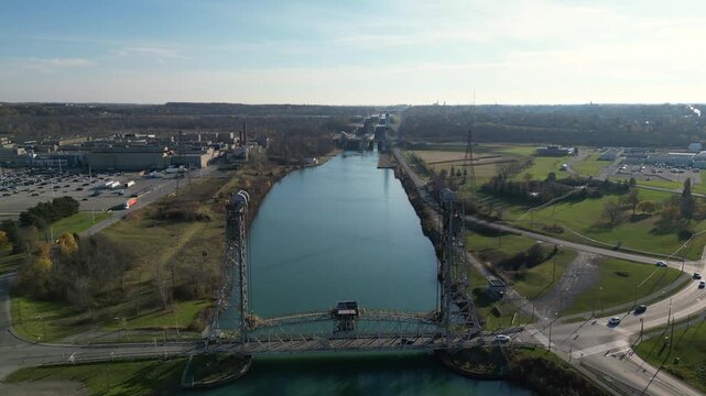 Aerial over the Welland Canal, part of the St. Lawrence Seaway  in St. Catharines, Ontario, Canada. Moving backwards, Glendale Avenue Bridge and lock 5 in Thorold. Autumn, November 2024.