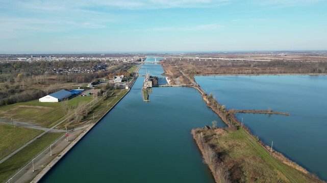 Aerial over the Welland Canal, St. Lawrence Seaway in St. Catharines, Ontario, Canada. Towards lock 3, Garden City Skyway bridge, Niagara-on-the-Lake and Lake Ontario. Autumn, November 2024.