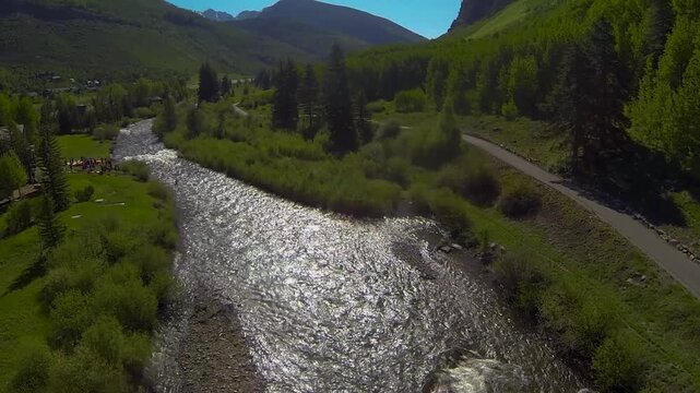 Drone shot booming down to a kayaker floating down a river