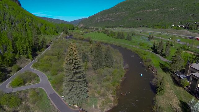 Drone shot of a green tree filled mountain and flowing river