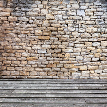 Old stone block wall with rough wood plank flooring background 