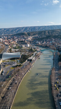 vertical aerial view of mtkvari river rhike park and bridge of peace in tbilisi georgia