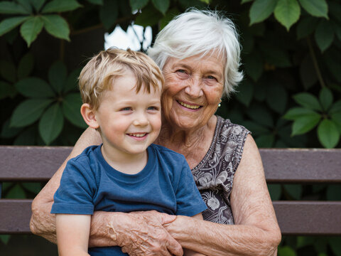Grandmother sitting on a bench with her grandson in a park enjoying their time together
