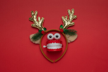 Festive Reindeer Themed Toy Chattering Teeth on Red Background © kvladimirv
