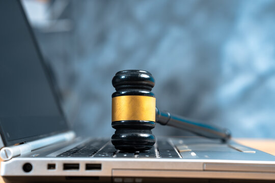 A judge's gavel resting on a keyboard