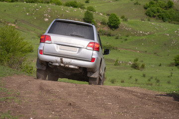 The car drives on a muddy, bad off-road road. © Daniel