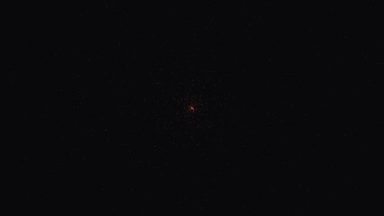 A single glowing orange point of light surrounded by a faint circular nebula of dust particles against a deep black space background © TUL