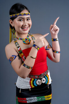 Portrait of young girl pointing fingers right in traditional cloth Simba Murut Tahol native of Sabah Borneo