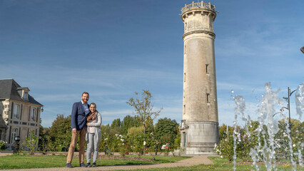 Couple posing beside historic stone tower in Honfleur, ideal for travel themes © PietFoto