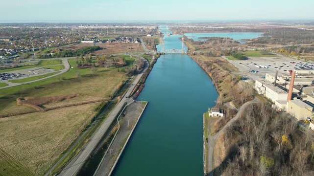 Aerial over the Welland Canal, part of the St. Lawrence Seaway and Great Lakes Waterway in St. Catharines, Ontario, Canada. Glendale Avenue Lift Bridge onto lock 3, Lake Ontario. November 2024. 