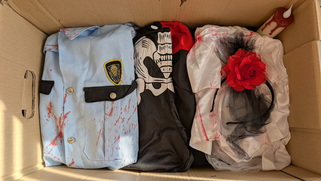 Halloween costumes and decorations stored in a cardboard box. 