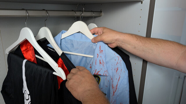 Man selecting a Halloween costume from a closet. 