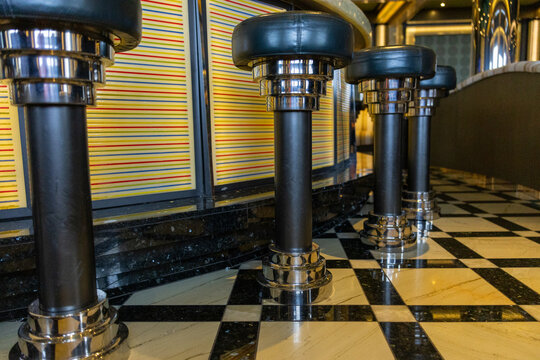 Retro style bar stools with chrome bases and colorful striped wall panels