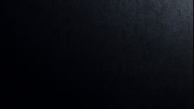 Dark black fabric texture with diagonal weave pattern and soft light highlight on the side 4k video