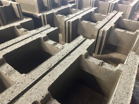 Grey concrete hollow blocks stacked in warehouse factory