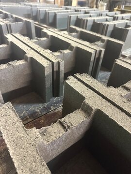 Vertical view of grey concrete hollow blocks in factory production