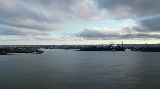 Aerial over Hamilton Harbour. The industrial sector of Hamilton, Ontario, Canada with factory smokestacks in the distance. Shot on an afternoon before sunset in October, 2024. Part 1 of 2.