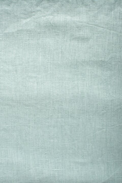 Top view macro photograph of washed natural linen fabric in light mint green