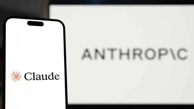 The Claude logo displayed on a smartphone held in front of a laptop. Anthropic Launches Claude Haiku 5.5 for Fast, Low-Cost AI Tasks. October 7, 2026, Lisbon, Portugal.