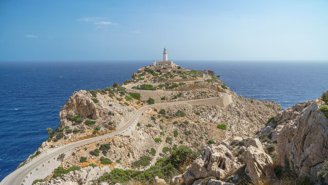 White lighthouse (Far de Formentor) overlooks winding coastal road at Cap Formentor in Mallorca, ideal for travel projects
